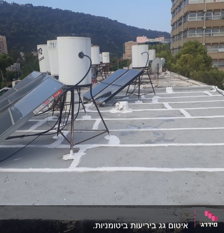 גג עם קווים לבנים לאיטום סביב קולטי שמש